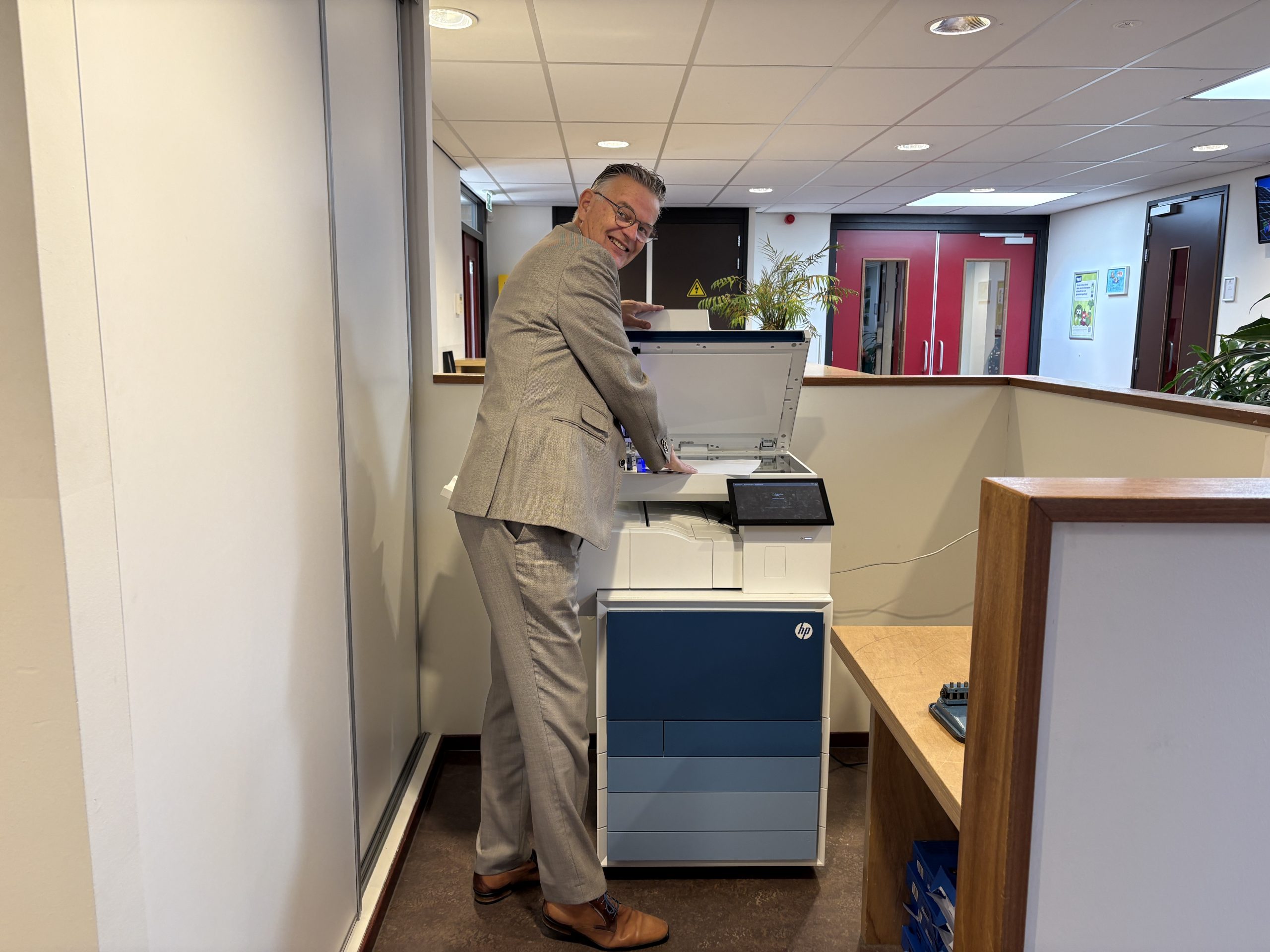 Directeur van de J.H. Donnerschool bij printer – voorbeeld van veilig printen in het speciaal onderwijs met Avictus